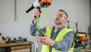 A person testing a grass trimmer after replacing the line.