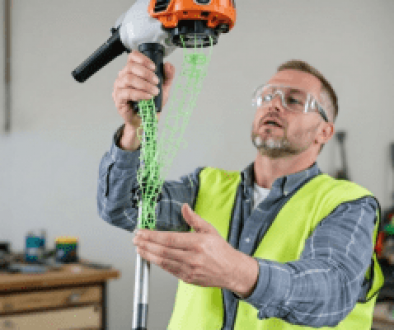 A person testing a grass trimmer after replacing the line.